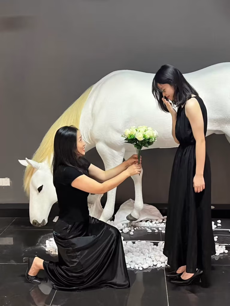 Bionic horse sculpture at Zhuhai mall – young girl kneeling offering flowers to white kinetic steed Creetiv 2025