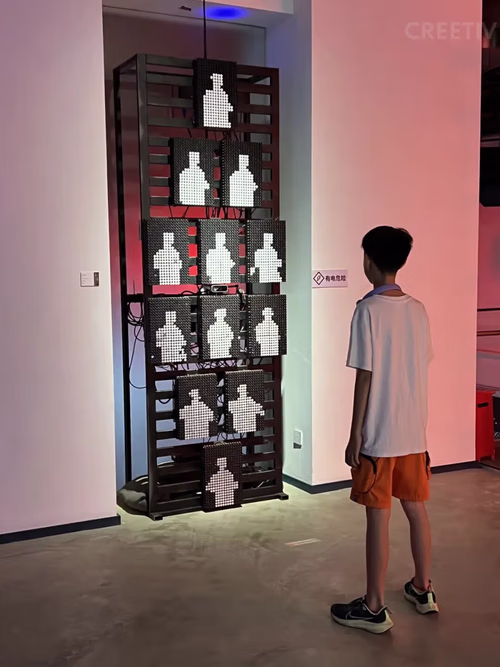 Child interacting with Flip-Dot Kinetic Wall displaying real-time pixelated portrait