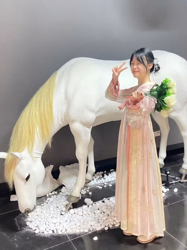 Child posing with victory sign beside Creetiv bionic horse kinetic art installation Zhuhai mall 2025
