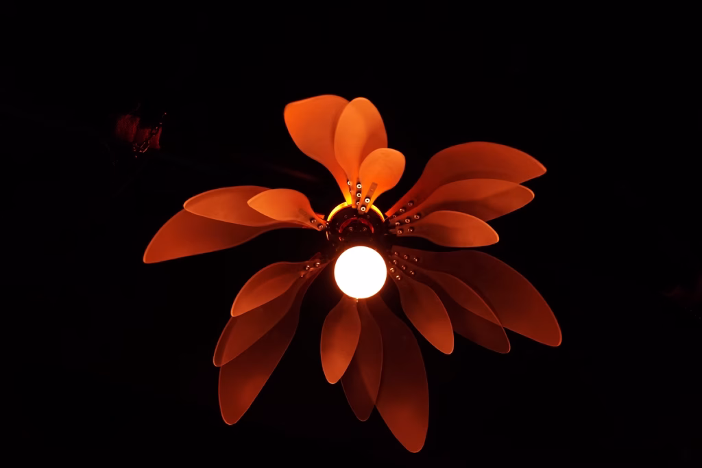 The petals of the ethereal kinetic flower are detailed and bloom in orange